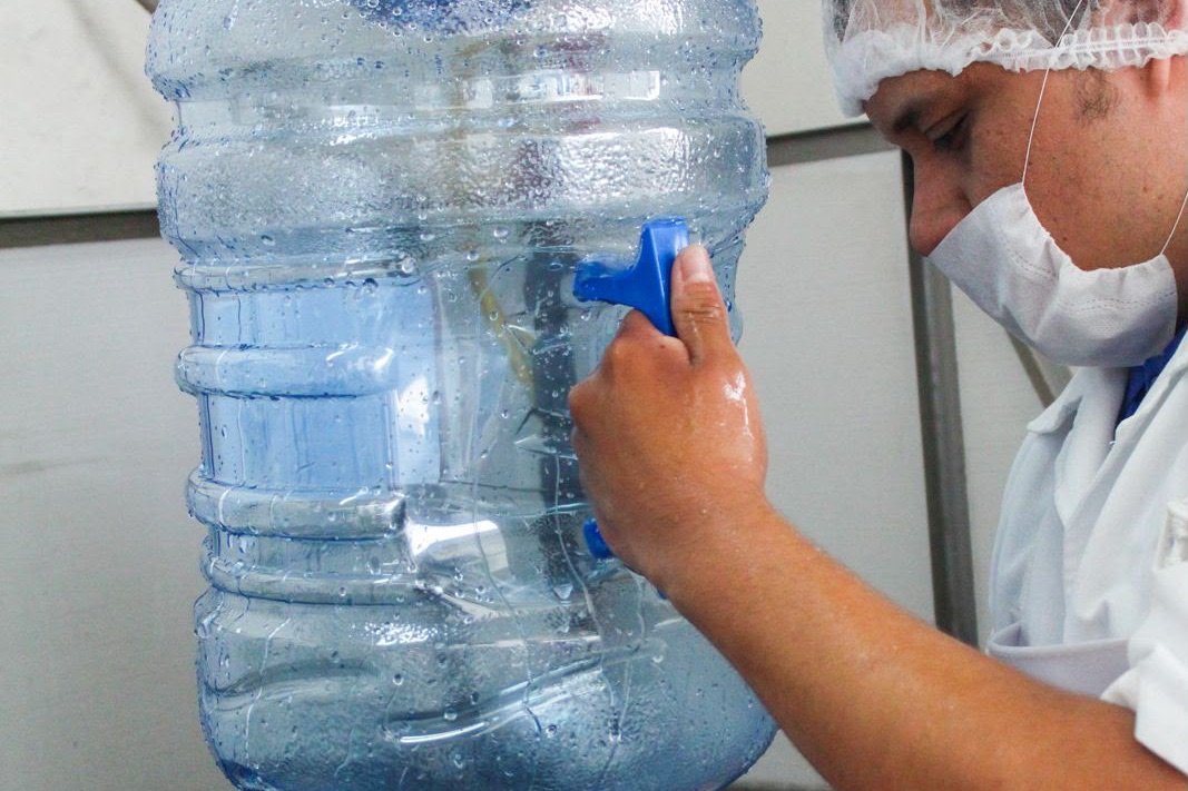 Operador vaciando y revisando un garrafón recién sanitizado
